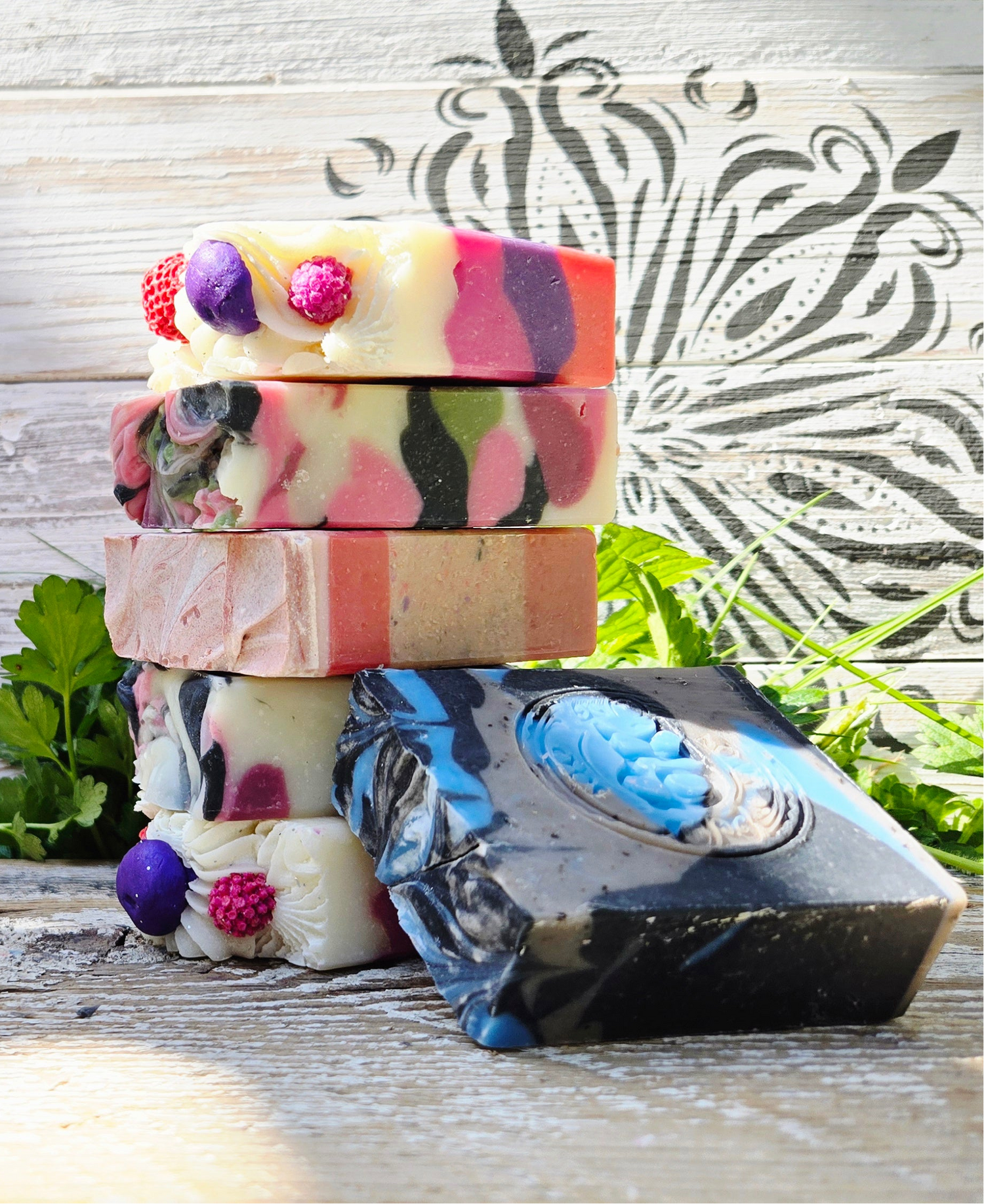 Stack of colorful soap bars on a wooden surface with a decorative background